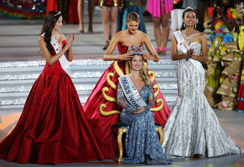 A spanyol Mireia Lalaguna Royo (k) megkapja a királynői koronát az előző évi nyertestől, a dél-afrikai Jolene Strausstól, miután győzött a 65. Miss World nemzetközi szépségversenyen a dél-kínai Hajnan-szigeten lévő Szanja tengerparti üdülőhelyen 2015. december 19-én. Mellette az első és második udvarhölgye, az orosz Szofija Nyikicsuk (b), illetve a második udvarhölgye, az indonéz Maria Harfanti. (MTI/EPA/Hou Hvi Jung)